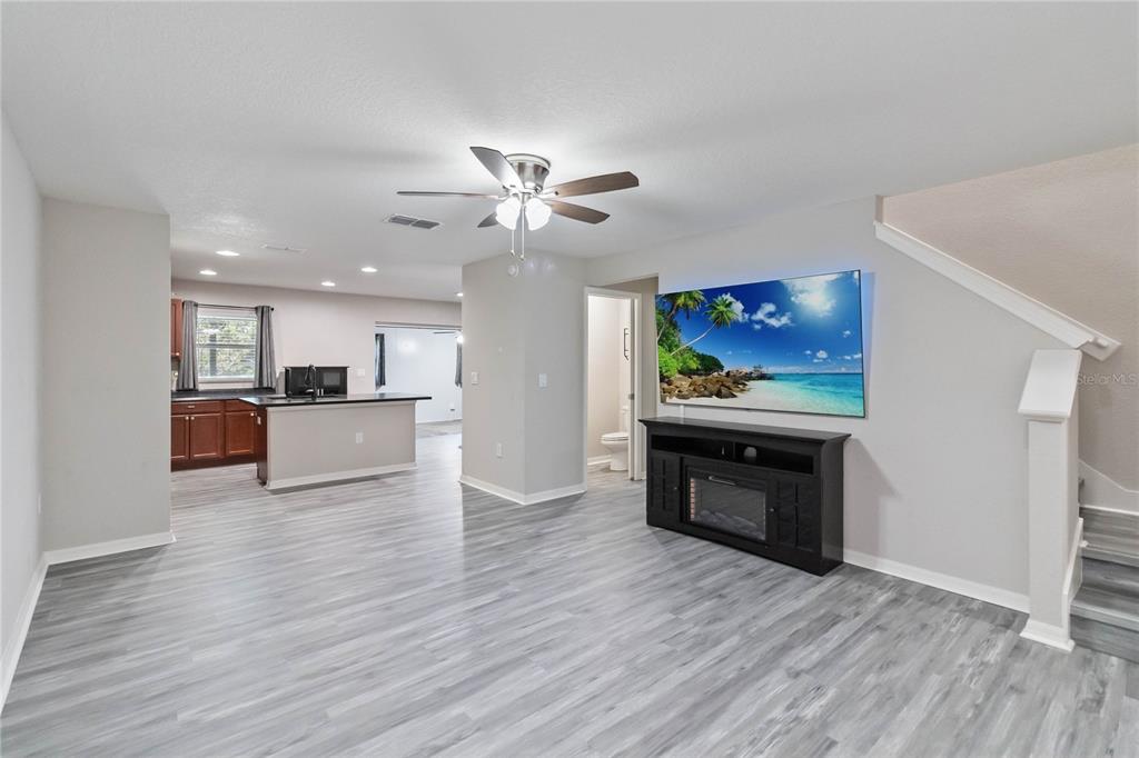 3723 Ricky Lane St. Cloud, FL 34772 - Photo 5 of 36 a view of an empty room and kitchen with wooden floor