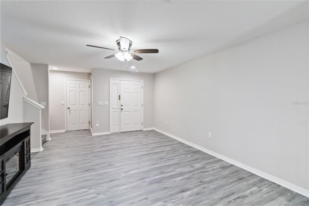 3723 Ricky Lane St. Cloud, FL 34772 - Photo 7 of 36 a view of an empty room with wooden floor and a ceiling fan