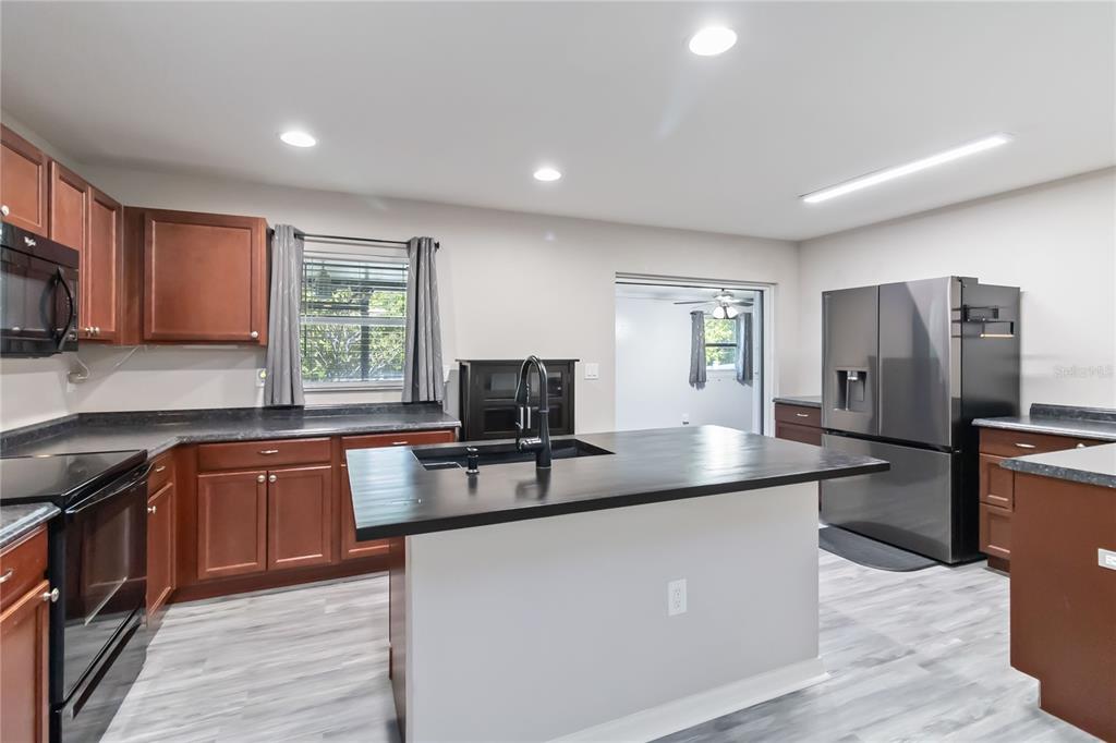3723 Ricky Lane St. Cloud, FL 34772 - Photo 9 of 36 a kitchen with stainless steel appliances granite countertop a sink a stove a refrigerator cabinets and a window