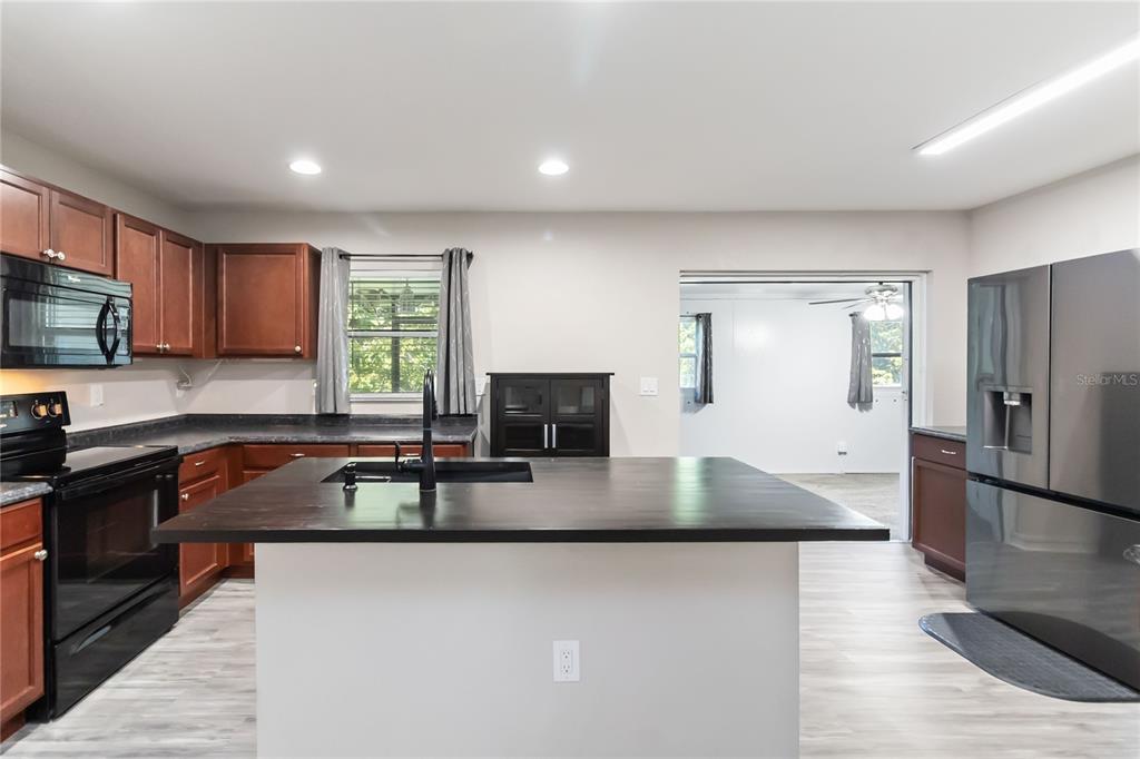 3723 Ricky Lane St. Cloud, FL 34772 - Photo 10 of 36 a kitchen with granite countertop a refrigerator and a sink