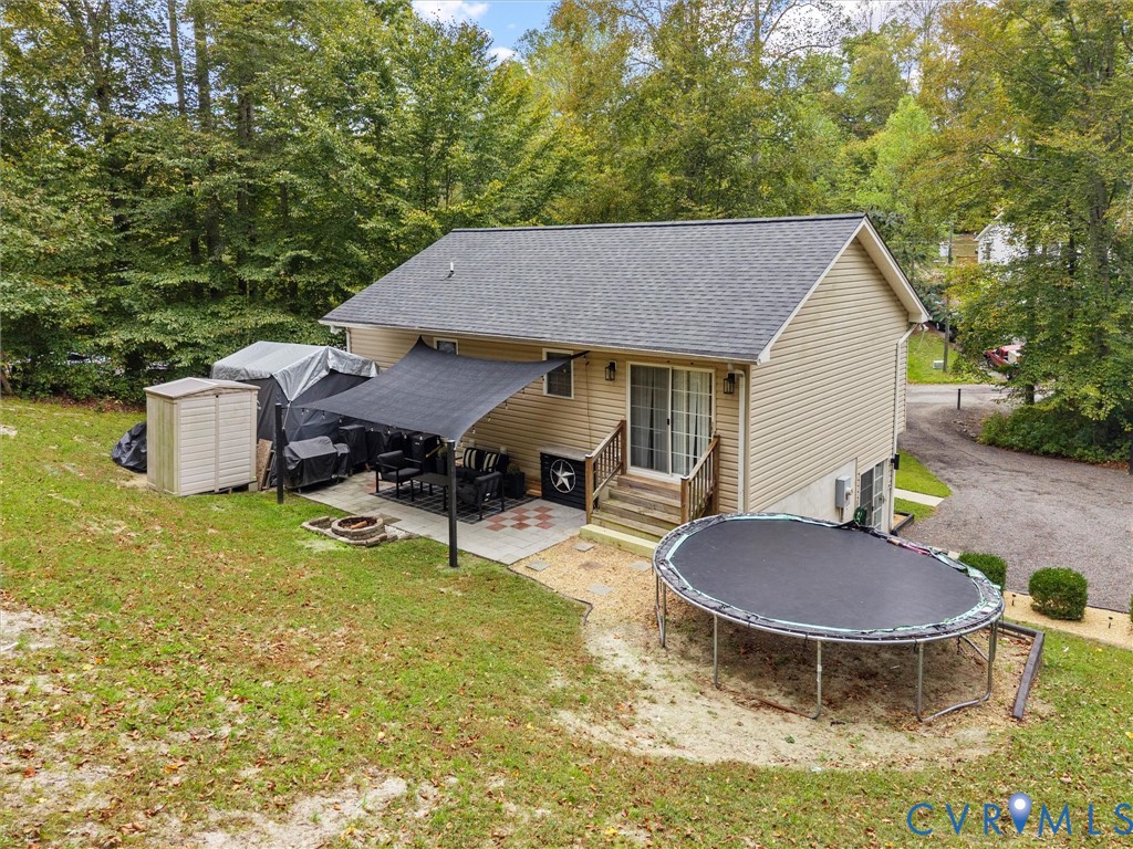 26315 Hill Road Ruther Glen, VA 22546 - Photo 45 of 47 Back of property with a trampoline, a patio area,