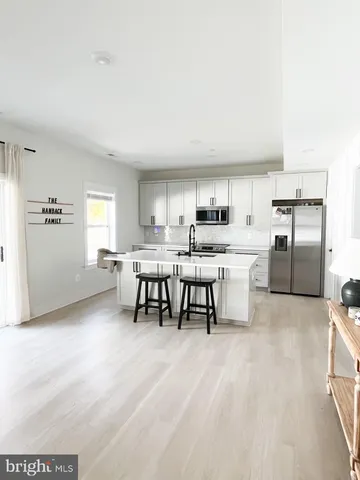 a kitchen with stainless steel appliances kitchen island granite countertop a sink and cabinets