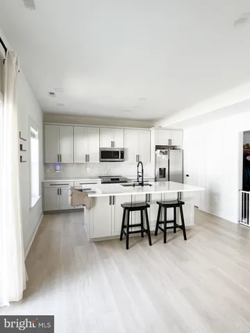 a kitchen with appliances a sink and cabinets