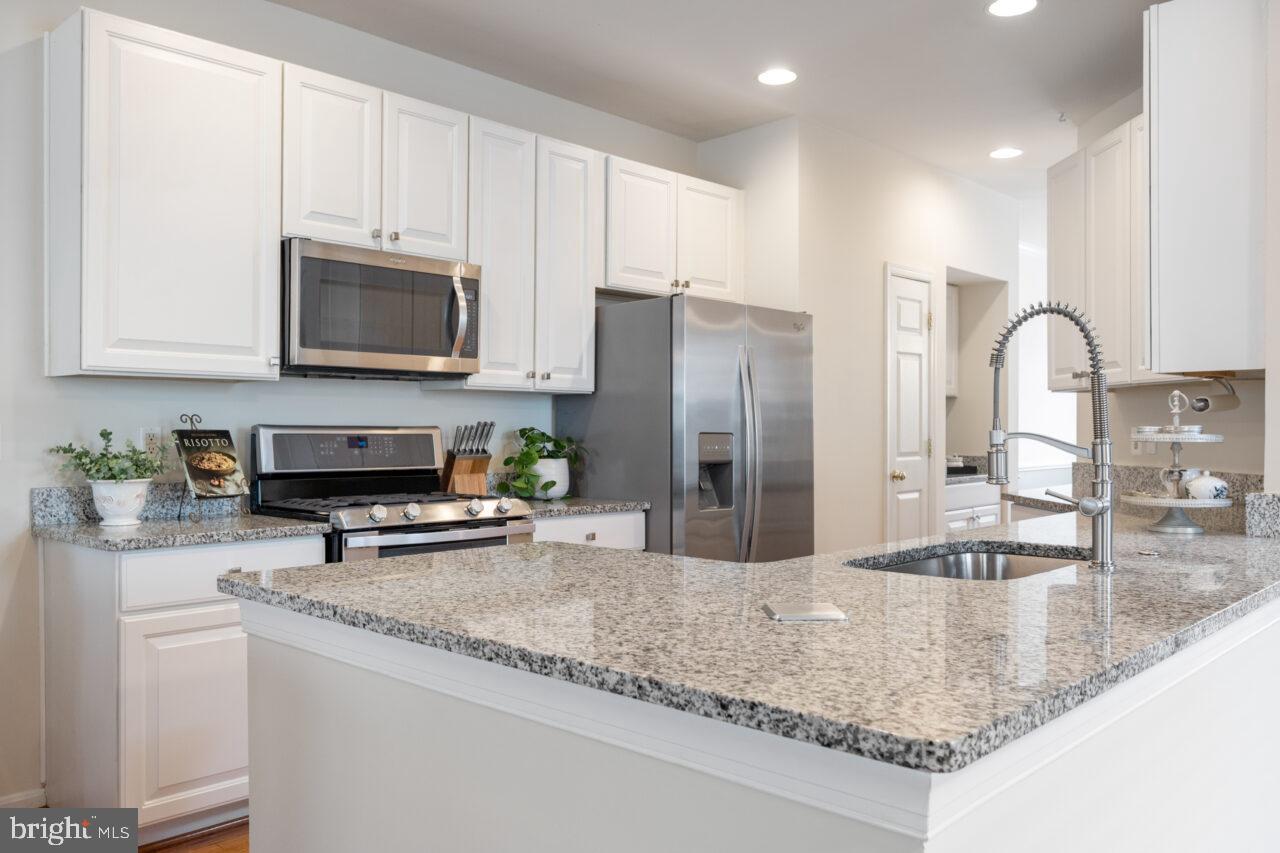 47799 Scotsborough Square Sterling, VA 20165 - Photo 7 of 53 a kitchen with stainless steel appliances granite countertop a sink a stove and cabinets