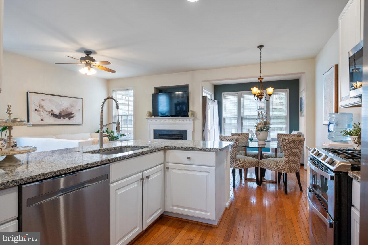 47799 Scotsborough Square Sterling, VA 20165 - Photo 8 of 53 a kitchen with granite countertop a stove a sink a dining table and chairs