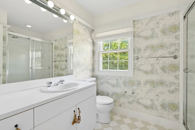 a bathroom with a double vanity sink mirror and toilet