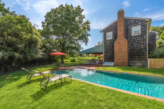 a view of a house with swimming pool and sitting area