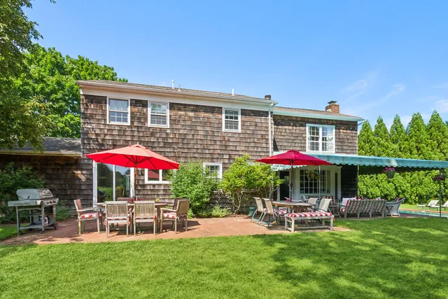 a view of patio with chairs and table under an umbrella