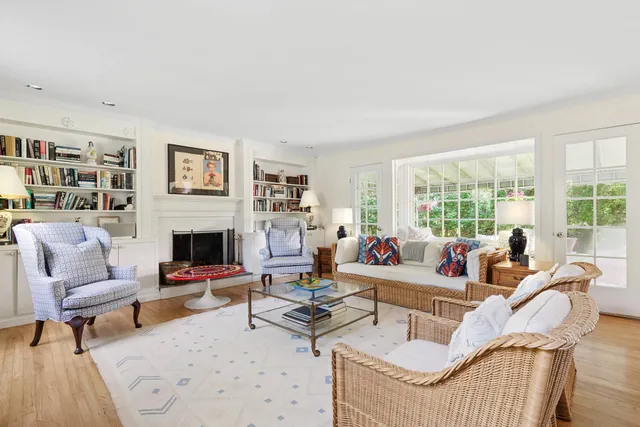 a living room with furniture fireplace and a large window