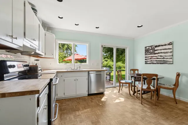 a kitchen with a stove a sink a dining table and chairs