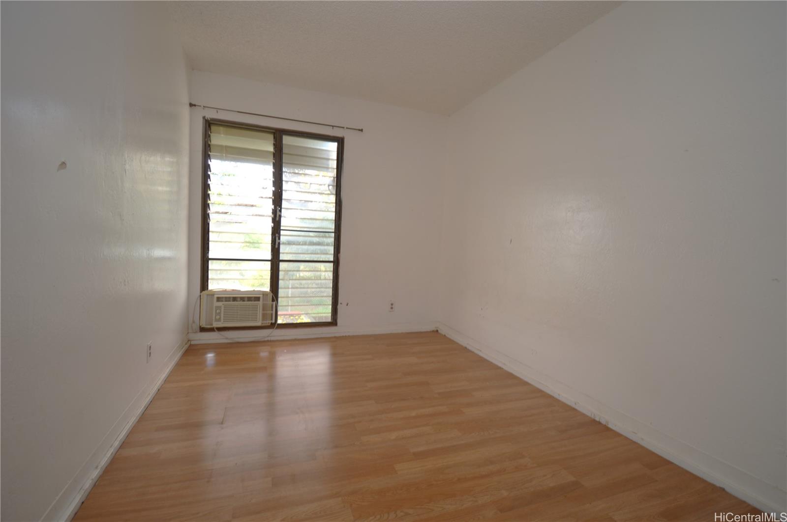 87-21317 Helelua Place, Unit 7 Waianae, HI 96792 - Photo 11 of 21 an empty room with wooden floor and windows