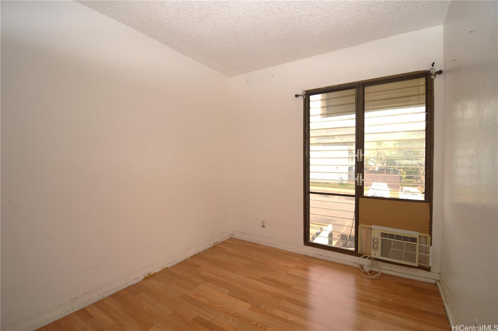 87-21317 Helelua Place, Unit 7 Waianae, HI 96792 - Photo 13 of 21 an empty room with wooden floor and windows