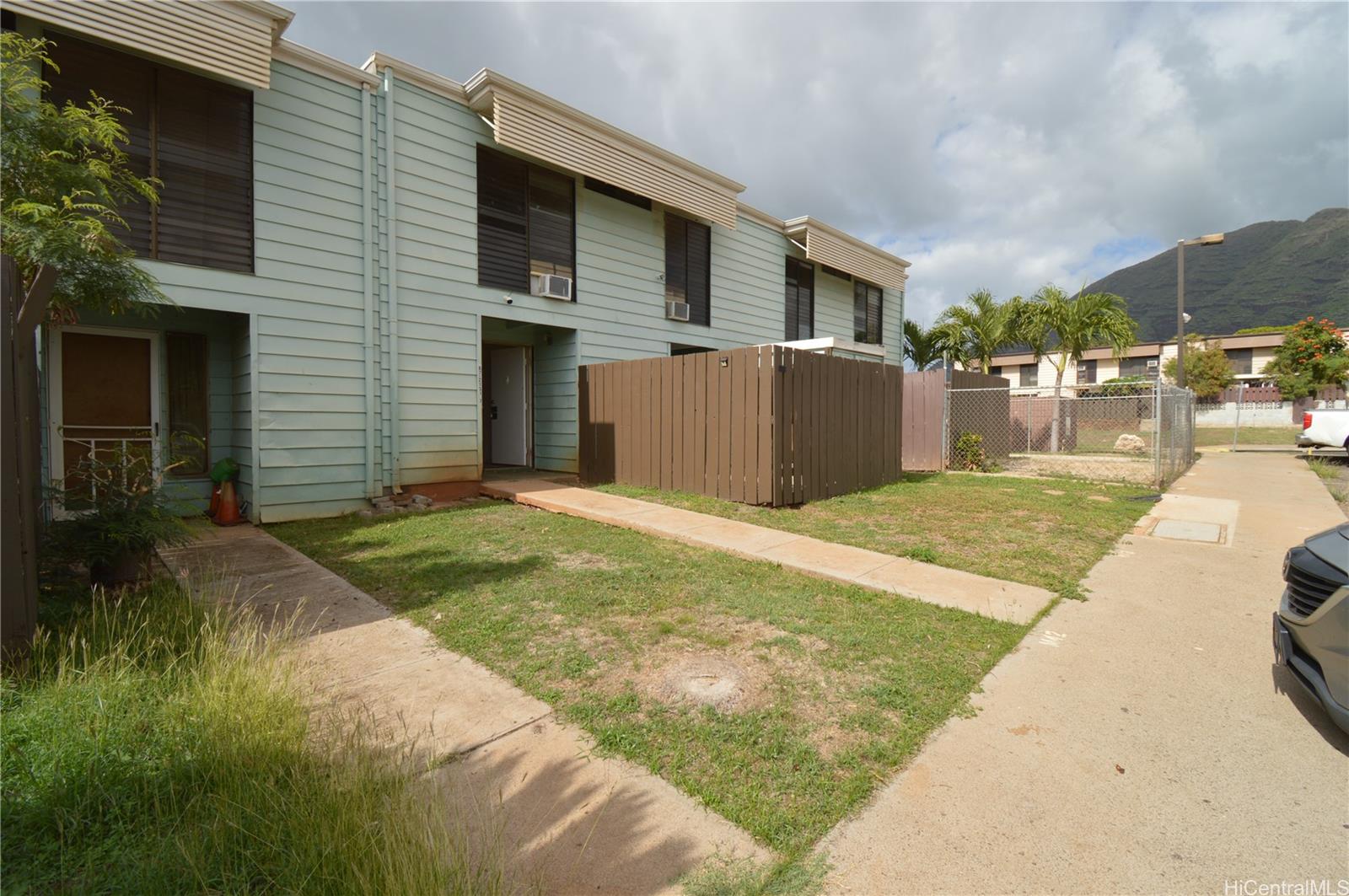 87-21317 Helelua Place, Unit 7 Waianae, HI 96792 - Photo 2 of 21 a front view of a house with a yard