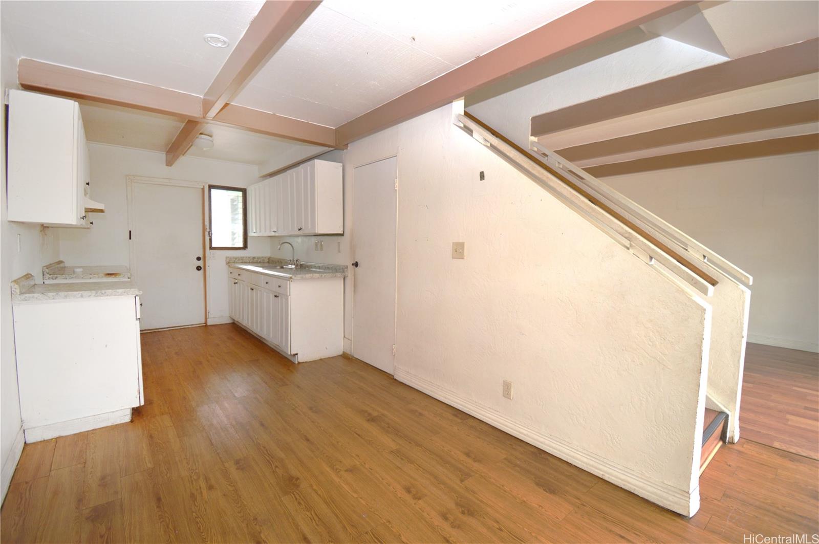 87-21317 Helelua Place, Unit 7 Waianae, HI 96792 - Photo 9 of 21 a kitchen with a sink a stove cabinets and wooden floor