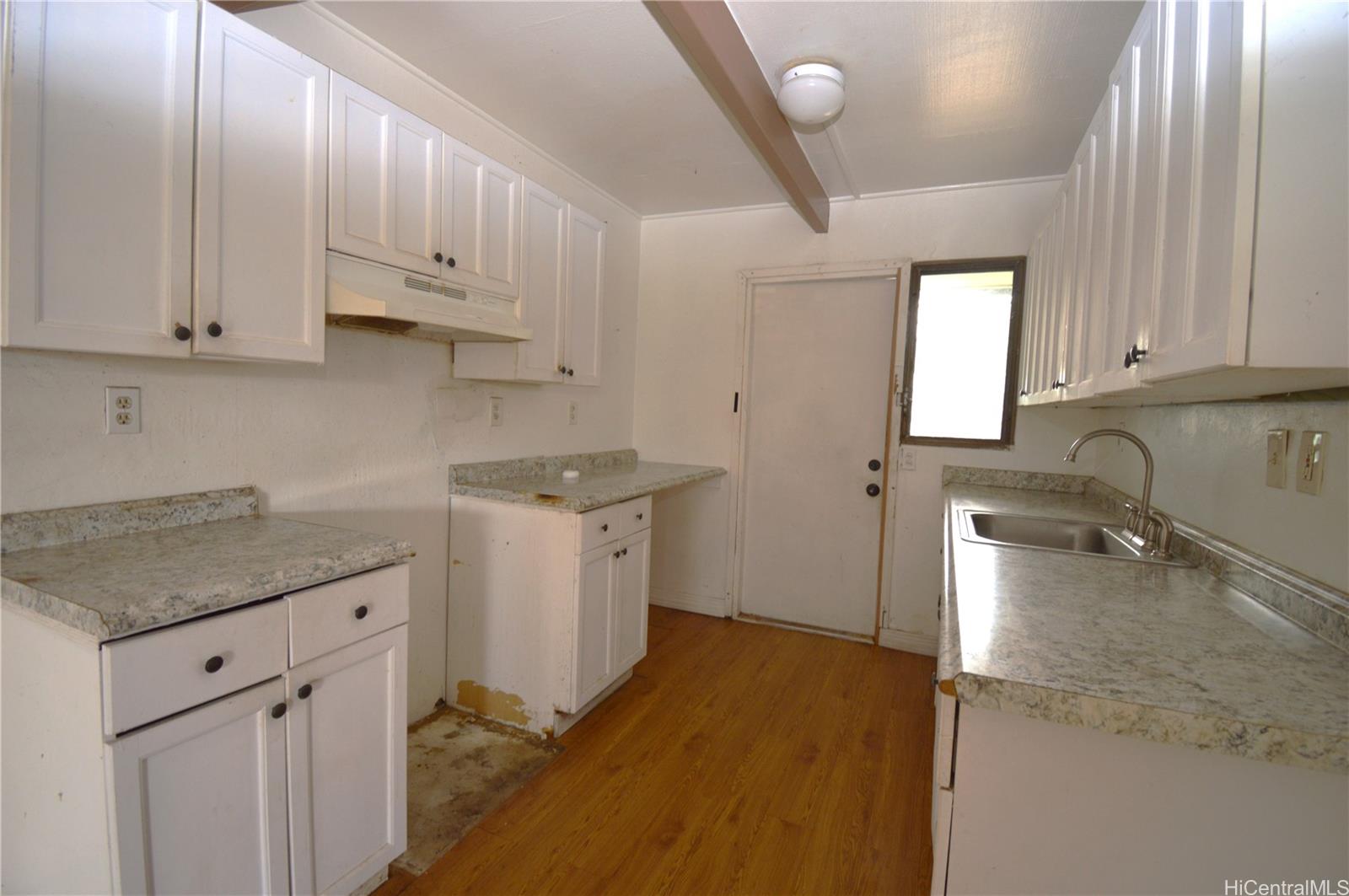 87-21317 Helelua Place, Unit 7 Waianae, HI 96792 - Photo 10 of 21 a kitchen with sink cabinets and window