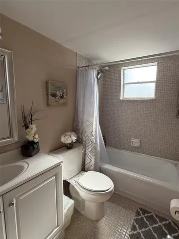 a white toilet sitting next to a bath tub