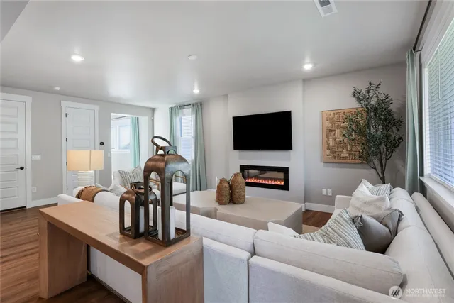 a living room with furniture a flat screen tv and a window