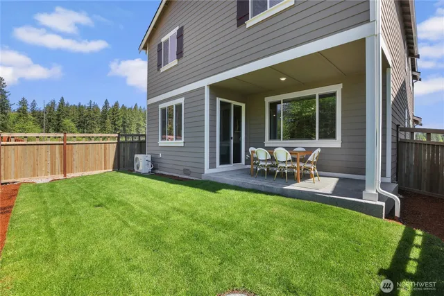 a view of backyard of house with outdoor seating and green space