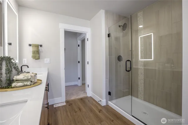 a bathroom with a tub shower vanity and a sink