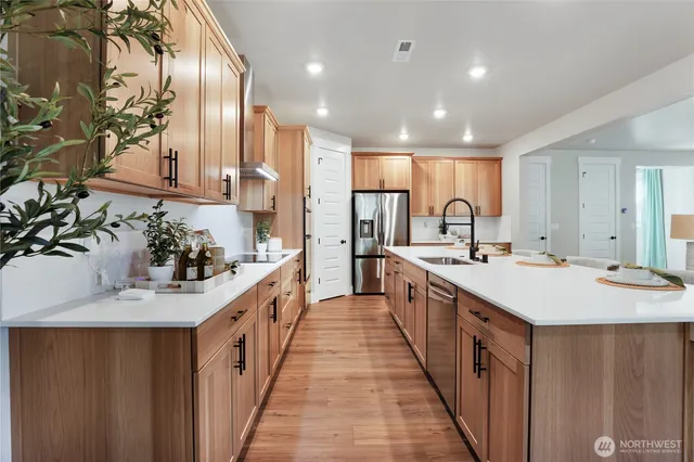 a large kitchen with kitchen island a sink a stove and a refrigerator
