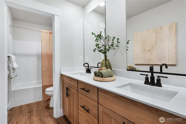 a bathroom with a double vanity sink and a toilet