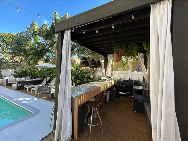 a view of deck with table and chairs a barbeque with wooden fence and floor
