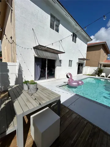a view of a patio with table and chairs with wooden floor and fence