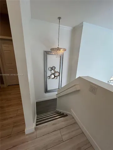 a view of staircase with wooden floor and white walls