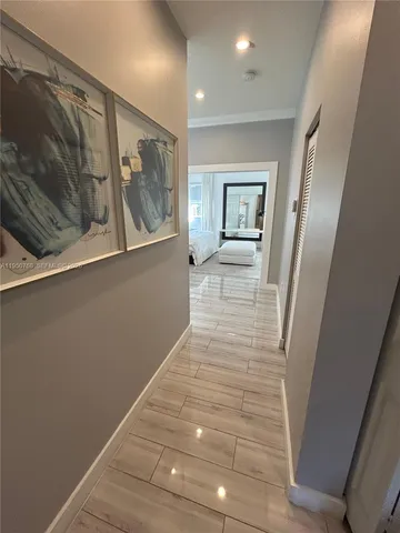 a view of a hallway with wooden floor and cabinet
