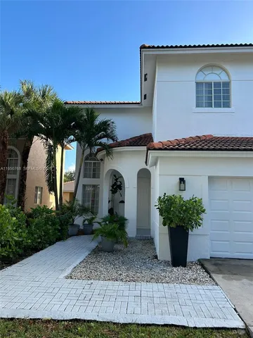 a front view of a house with plants