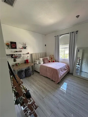 a bedroom with a bed and wooden floor