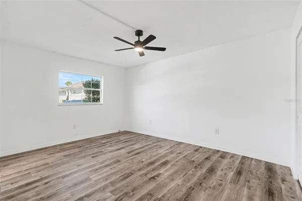 a view of empty room with wooden floor