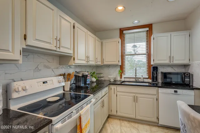 a kitchen with stainless steel appliances granite countertop a sink stove and cabinets