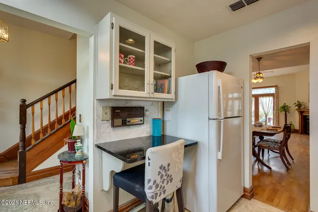 a kitchen with stainless steel appliances granite countertop a refrigerator and a dining table