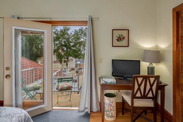 a view of a workspace with furniture and a window