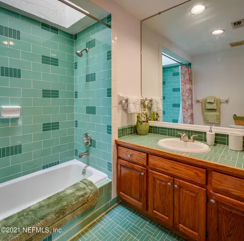 a spacious bathroom with a granite countertop sink and a mirror