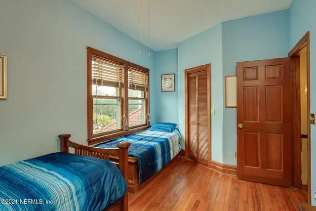 a bedroom with two beds and a closet