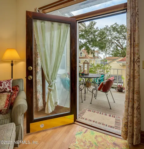 a living room with large glass windows and furniture