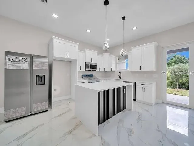 a view of a kitchen with a sink and a large mirror in a room