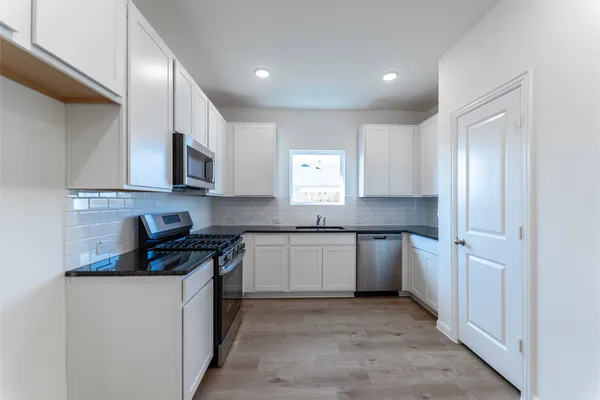 a kitchen with a sink stove and cabinets