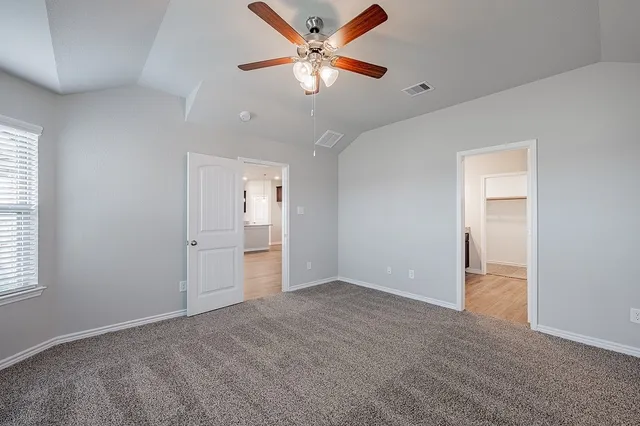 an empty room with closet and a ceiling fan