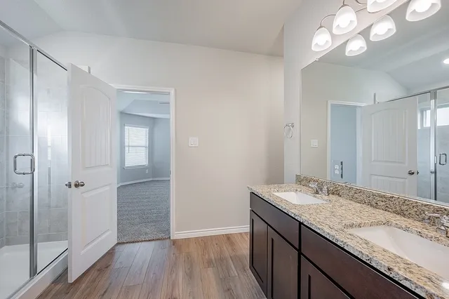 a bathroom with a granite countertop sink a light fixture and a mirror