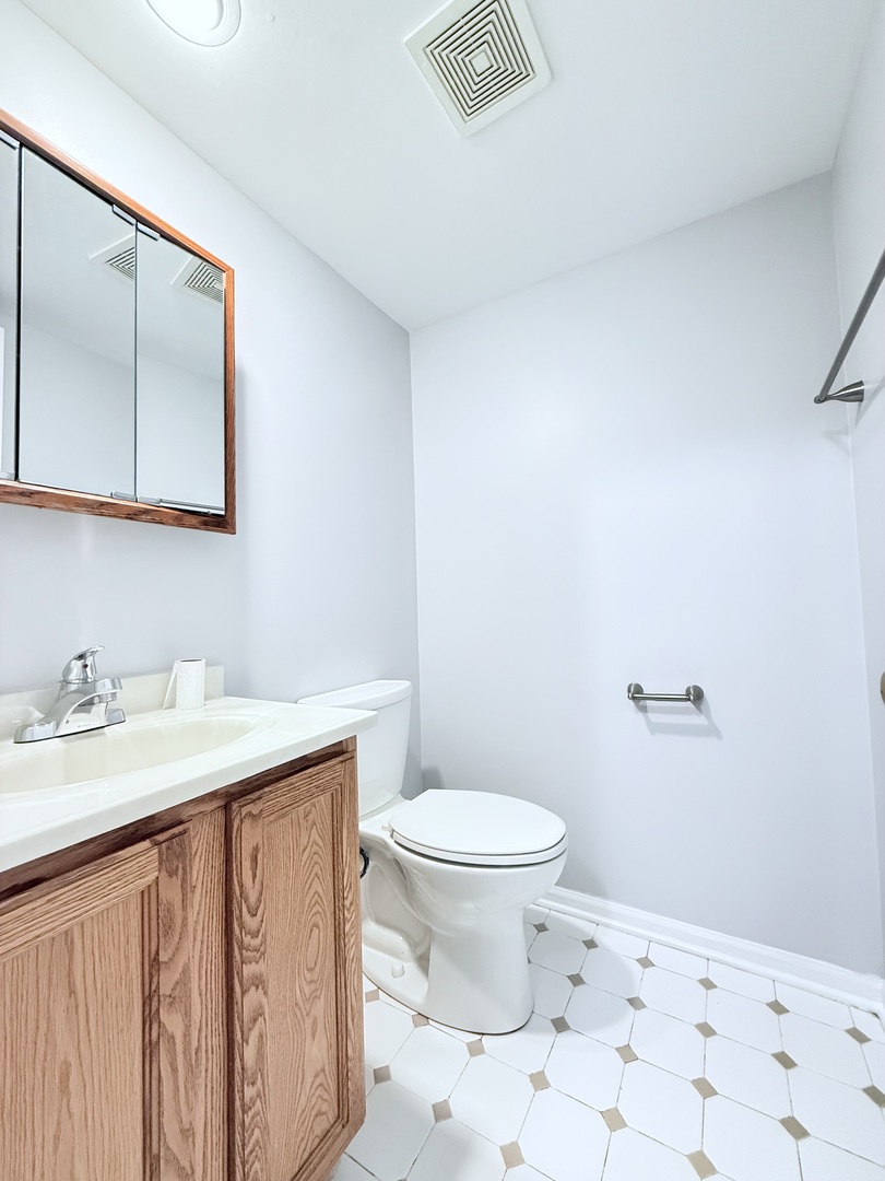 218 East Bailey Road, Unit M Naperville, IL 60565 - Photo 10 of 16 a bathroom with a granite countertop sink a toilet and a mirror