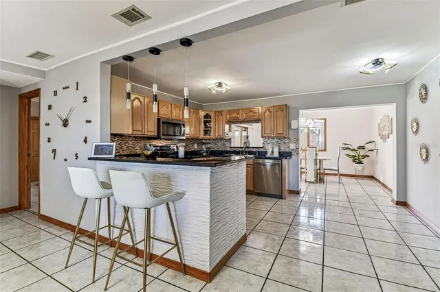 a kitchen with granite countertop a refrigerator and a stove top oven