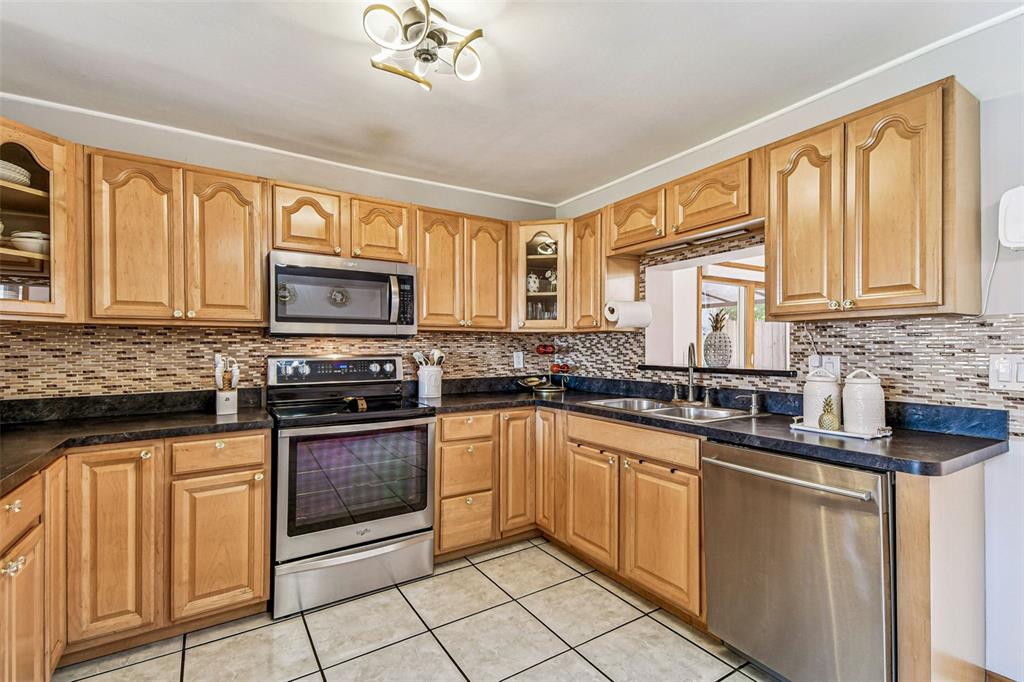 226 Maple Avenue Palm Harbor, FL 34684 - Photo 17 of 79 a kitchen with stainless steel appliances granite countertop a stove sink microwave and cabinets