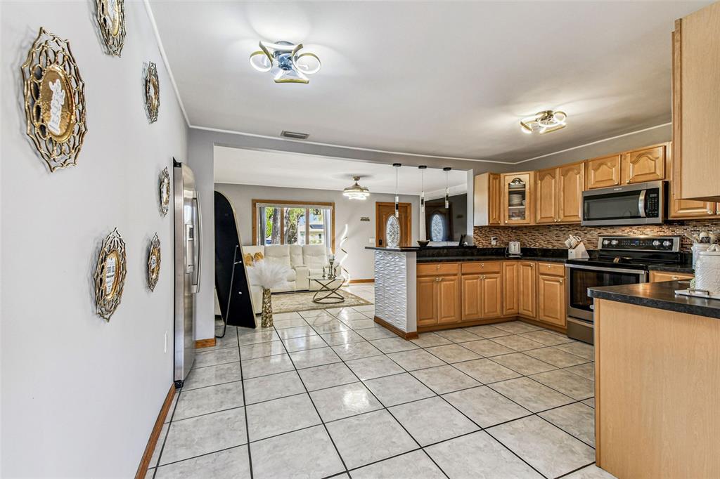 226 Maple Avenue Palm Harbor, FL 34684 - Photo 25 of 79 a kitchen with granite countertop a refrigerator and a stove top oven