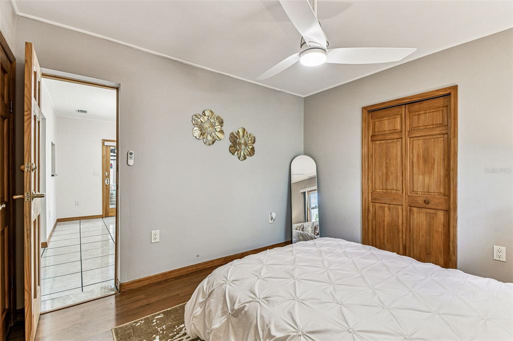 226 Maple Avenue Palm Harbor, FL 34684 - Photo 27 of 79 a bedroom with a bed and a chandelier