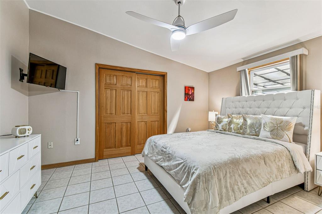 226 Maple Avenue Palm Harbor, FL 34684 - Photo 31 of 79 a bedroom with a large bed a flat tv screen and dresser