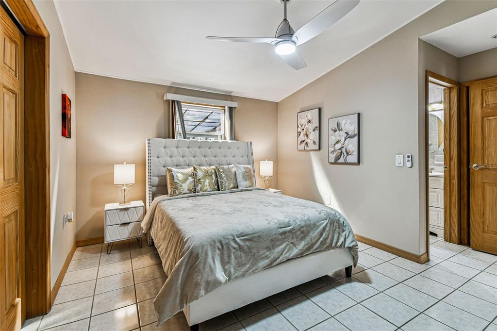 226 Maple Avenue Palm Harbor, FL 34684 - Photo 35 of 79 a bedroom with a large bed and a chandelier