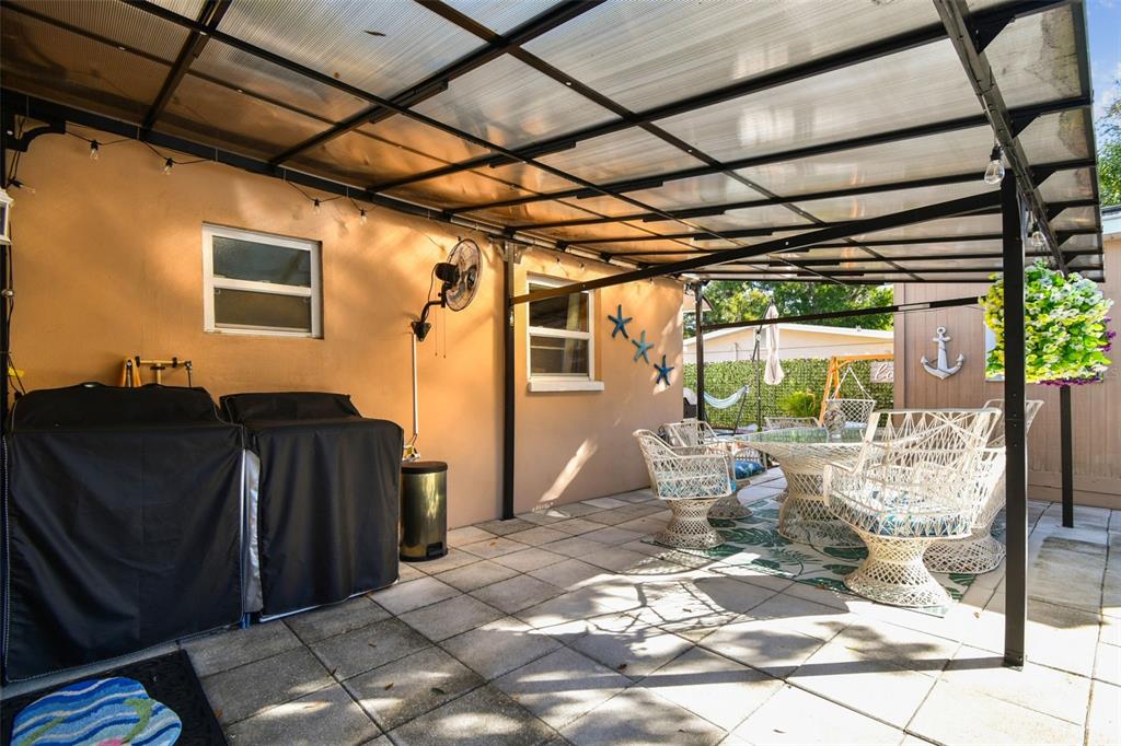 226 Maple Avenue Palm Harbor, FL 34684 - Photo 42 of 79 a view of a patio with table and chairs and potted plants